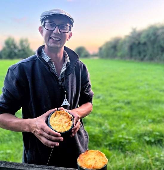 Karl Franklin holding a small shepherd's pie in a green field